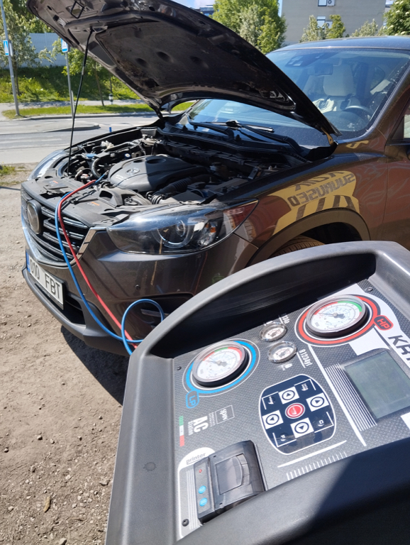 Autokliima täitmise seade avatud kapoti juures